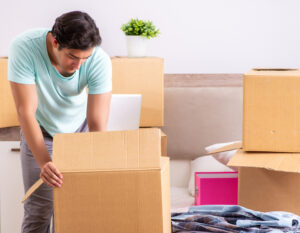 Family quickly packing moving boxes during a last-minute move with emergency packing hacks and supplies scattered around the room